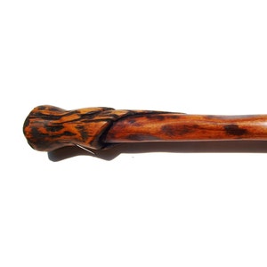 May include: A wooden walking stick with a carved, knotty handle. The handle is a dark brown color, while the rest of the stick is a lighter brown.