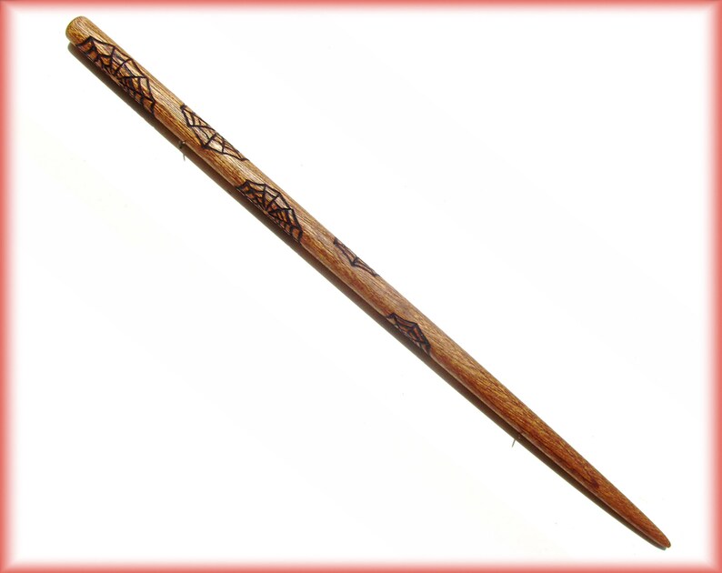 Op de afbeelding: Een houten haarstok met een donkerbruine afwerking en een spinnenwebontwerp. De stok is ongeveer 25 cm lang.