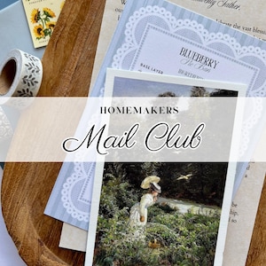 May include: A collection of stationery items including a postcard with a painting of a person in a white dress holding a yellow parasol in a forest, a recipe card for Blueberry Pie Bars, a sheet of sunflower stamps, and a roll of leaf-patterned washi tape.