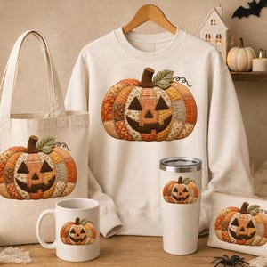 May include: A cream-coloured sweatshirt, a canvas tote bag, a ceramic mug, a stainless steel tumbler, and a small rectangular pouch, each featuring a graphic of a patchwork-style jack-o'-lantern pumpkin with orange, brown, and yellow fabric patterns.