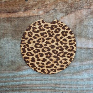 May include: A round brown and tan leopard print car coaster.