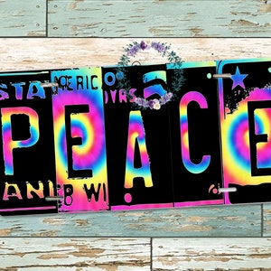 May include: A black metal sign with the word "PEACE" in white letters. The letters are surrounded by colorful tie-dye patterns.