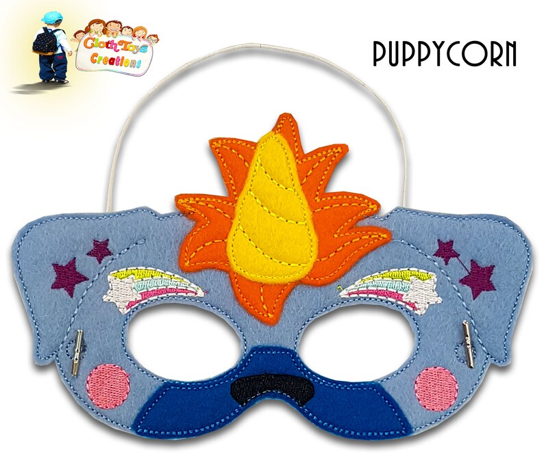 May include: A blue felt unicorn puppycorn mask with a yellow horn, orange mane, and rainbow embroidered details. The mask has two pink circles and two purple stars on the sides. The mask has an elastic band for wearing.