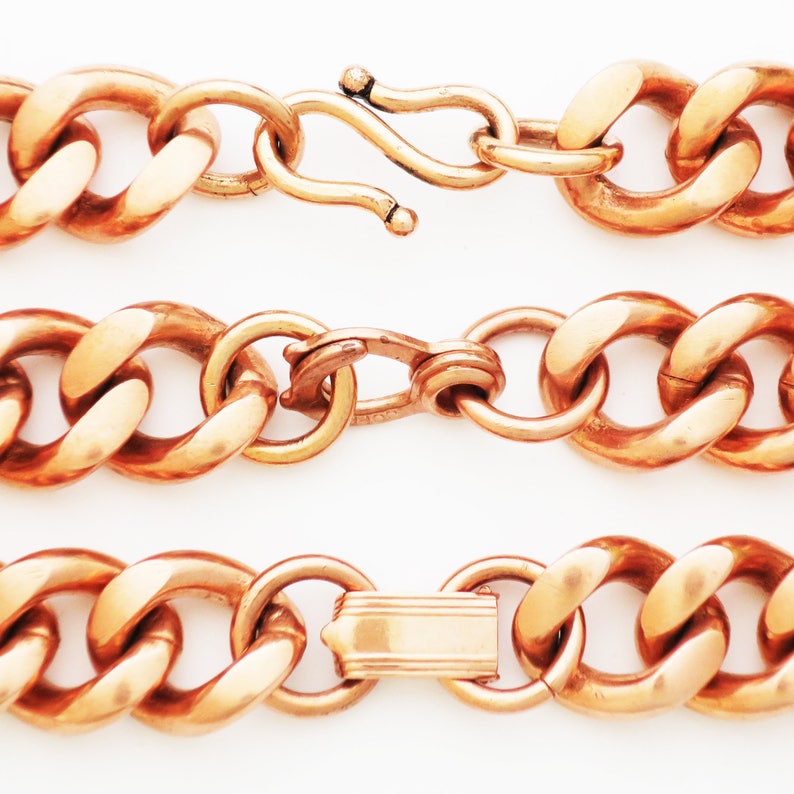 May include: A copper chain necklace with three different clasp styles. The chain is thick and has a curb link design.