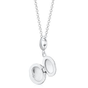 Puede incluir: Un collar con un medall&oacute;n ovalado de plata que se abre para revelar un peque&ntilde;o espacio. El medall&oacute;n cuelga de una delicada cadena. El medall&oacute;n est&aacute; abierto, mostrando el interior. El collar est&aacute; hecho de metal brillante y reflectante.
