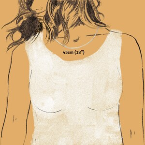 Puede incluir: Ilustraci&oacute;n de un collar plateado, de 45 cm (18 pulgadas) de largo, sobre el pecho de una persona. La persona lleva una camiseta sin mangas blanca. El texto "45cm (18")" se muestra encima del collar.