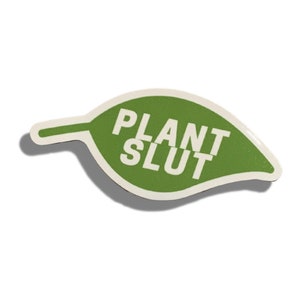 May include: Green leaf-shaped sticker with the text "PLANT SLUT" in white letters.
