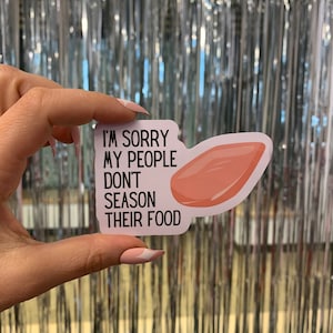 May include: A white sticker with black text that reads "I'm sorry my people don't season their food." A pink meat cut-out is on the right side of the sticker.