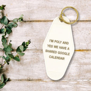 Lifestyle photo of I'm Poly and Yes We Have a Shared Google Calendar Motel Style Keychain designed with leaves on the side