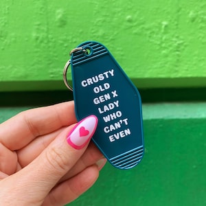 May include: Teal blue motel key tag with white text that reads "CRUSTY OLD GEN X LADY WHO CAN'T EVEN".