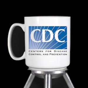 May include: White ceramic mug with a blue and white CDC logo and the text "Centers for Disease Control and Prevention".