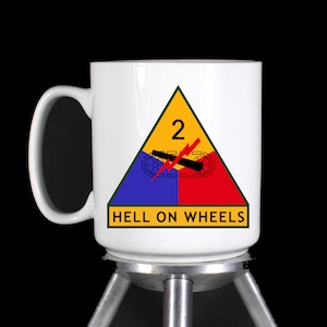 May include: White ceramic mug with a yellow, blue, and red triangle with the number "2" and the words "HELL ON WHEELS".