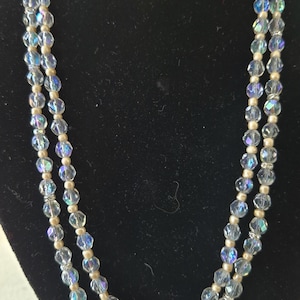 May include: A double strand necklace made of iridescent clear glass beads and smaller gold beads.