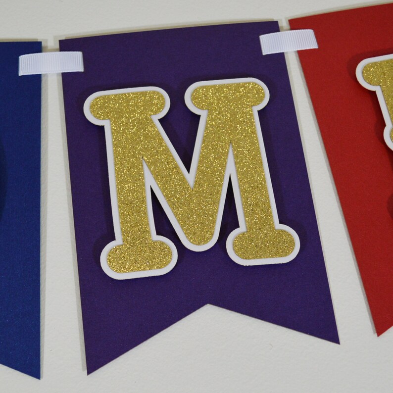 May include: Purple and red felt banner with gold glitter letters spelling "MOM".