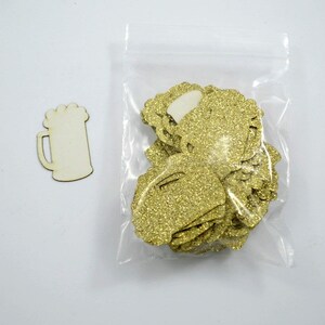 Beer mug shaped confetti pieces in gold glitter shown in their packaging.