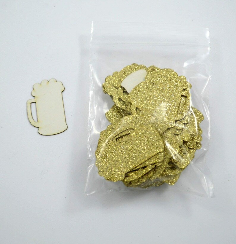 Beer mug shaped confetti pieces in gold glitter shown in their packaging.
