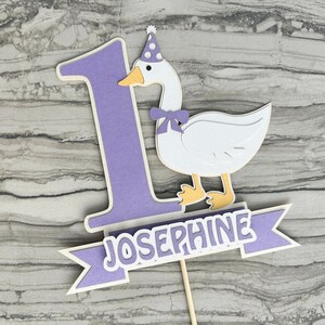 First birthday cake topper with a goose and personalized with the name Josephine.  Shown in the light purple accent color.