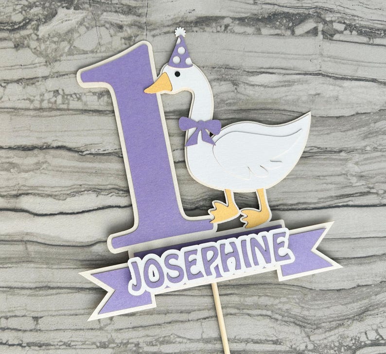 First birthday cake topper with a goose and personalized with the name Josephine.  Shown in the light purple accent color.
