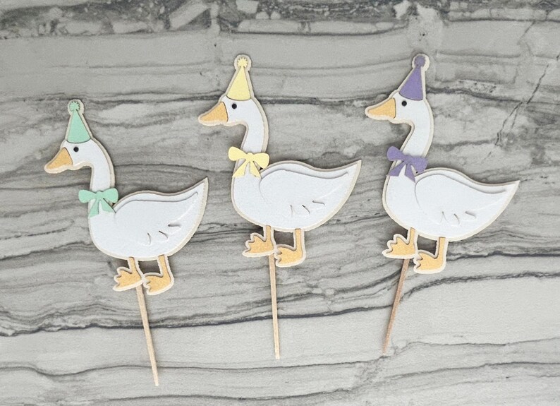 Three goose cupcake toppers shown in mint green, yellow, and light purple accent color options.