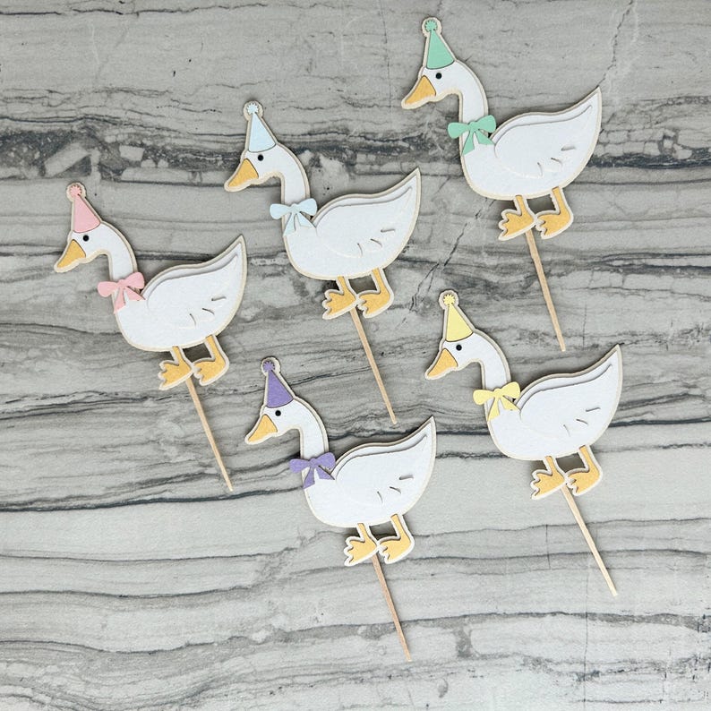 Five goose cupcake toppers shown in light pink, light blue, mint green, light purple, and yellow accent color options.