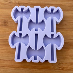 May include: A purple silicone mould with six axe shapes. The mould is designed to create small, detailed axe-shaped decorations.