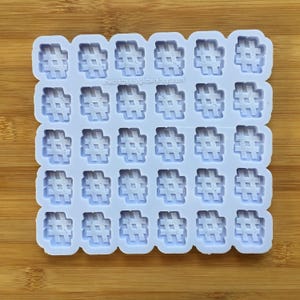 Puede incluir: Un molde de silicona con 36 formas de hashtag individuales. El molde es de color morado claro y tiene una superficie lisa. Las formas de hashtag están en relieve y tienen una superficie ligeramente texturizada. El molde está sobre una superficie de madera.