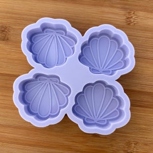 May include: A purple silicone mold with four shell-shaped cavities. The mold is designed for making resin crafts.