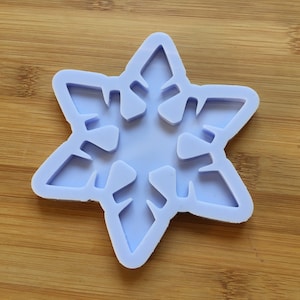 Può includere: Uno stampo in silicone color lavanda chiaro a forma di fiocco di neve a sei punte. Lo stampo presenta un centro incavato e intricati ritagli simmetrici lungo ciascuno dei sei bracci, creando un dettagliato motivo a stella per la colata.