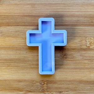 Peut inclure: Un moule en silicone de couleur violet clair en forme de croix.