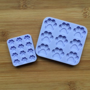 May include: Two silicone moulds for making paw print shapes. The larger mould has eight paw prints and the smaller mould has 15 paw prints.