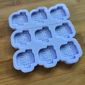 Può includere: Uno stampo in silicone viola con nove cavità a forma di cassette postali con cuori. Lo stampo è su una superficie di legno. Il testo "thecraftsandglittershop.com" è stampato sullo stampo.