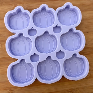 May include: A lavender silicone mould with nine pumpkin-shaped cavities. The mould is designed for making small pumpkin-shaped treats or decorations.