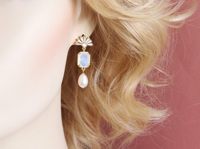 May include: Gold earrings with a white opal stone and a pearl drop.