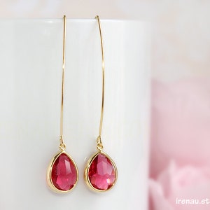Peut inclure: Une paire de boucles d'oreilles pendantes dorées avec des cristaux roses en forme de goutte.