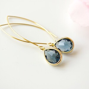 Peut inclure: Une paire de boucles d'oreilles en or en forme de goutte avec des pierres de cristal bleu foncé.