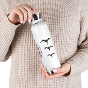 Könnte beinhalten: Eine weiße Wasserflasche aus Edelstahl mit einem schwarz-weißen Design von fliegenden Vögeln. Die Flasche hat einen Schraubverschluss.