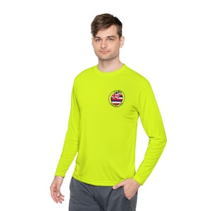 Könnte beinhalten: Ein leuchtend gelbes Langarmshirt mit einem runden Aufnäher auf der linken Brust. Der Aufnäher zeigt eine hawaiianische Flagge mit dem Text "ILWU LOCAL 142".