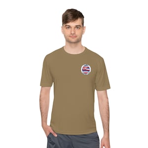 Könnte beinhalten: Ein khaki-farbenes T-Shirt mit kurzen Ärmeln und einem runden Aufnäher auf der linken Brust. Der Aufnäher zeigt einen weißen Kreis mit blauem Rand und dem Text "ILWU LOCAL 142" in blau. Im Inneren des Kreises befindet sich eine rot-weiß-blaue hawaiianische Flagge.