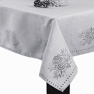 May include: A white tablecloth with a delicate pine cone design. The tablecloth has a subtle, embroidered pattern of pine cones and branches.