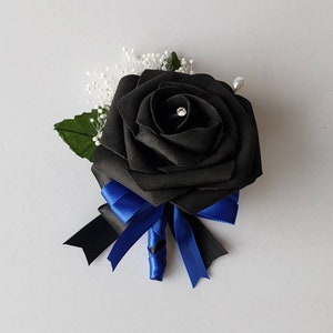 May include: A black satin rose buttonhole with a blue ribbon and white baby's breath.