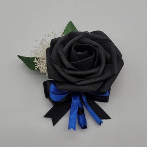May include: A black rose buttonhole with a blue and black ribbon.