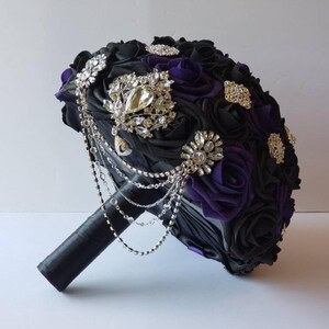 Dark purple and black bridal bouquet that has cascading chains and brooches scattered across bouquet