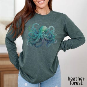 May include: A long-sleeved shirt in a dark green heather colour with a graphic print of a blue and green octopus.