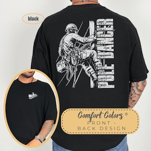 May include: Black t-shirt with a white graphic of a lineman climbing a utility pole. The text "POLE DANCER" is on the back of the shirt. The shirt is made by Comfort Colors.