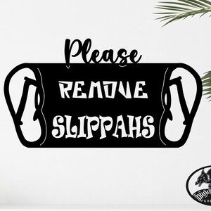 Może przedstawiać: Czarno-biały znak z tekstem "Please Remove Slippahs" z parą klapek po obu stronach tekstu. Znak znajduje się na białej ścianie.