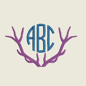 May include: A blue monogram "ABC" in a circle surrounded by purple antlers.