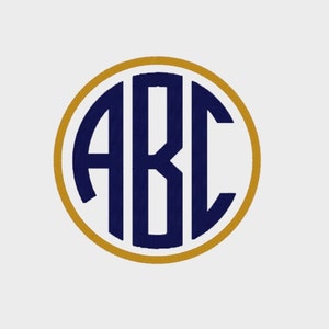 May include: Embroidered monogram with the letters ABC in navy blue, set within a gold-colored circle, against a white background. The design is simple and elegant, suitable for personalization.
