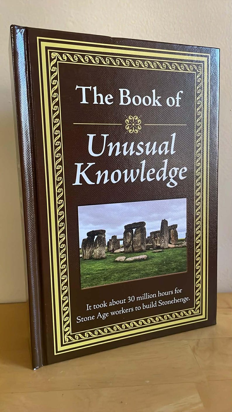 Puede incluir: Un libro de tapa dura titulado "The Book of Unusual Knowledge" con una cubierta marr&oacute;n y un borde decorativo dorado. La portada presenta una imagen de Stonehenge y el texto: "It took about 30 million hours for Stone Age workers to build Stonehenge."