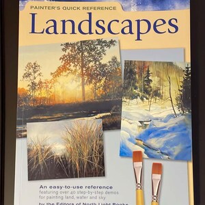 May include: A softcover instructional book titled Painter's Quick Reference Landscapes by the Editors of North Light Books. The cover features three landscape paintings, two paintbrushes with orange bristles, and text describing over 40 demos.