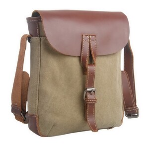 May include: A canvas messenger bag with a brown leather flap and accents. The bag features a khaki-colored canvas body, a brown leather shoulder strap, and a buckle closure. The leather is stitched with white thread.